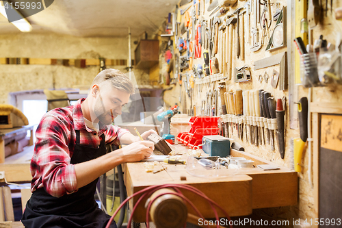 Image of carpenter working with wood plank at workshop