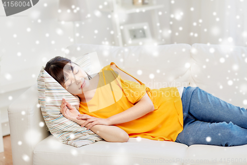 Image of happy asian teenage girl sleeping on sofa at home