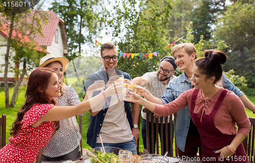 Image of happy friends having party at summer garden