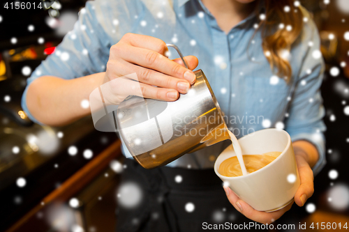 Image of close up of woman making coffee at shop or cafe