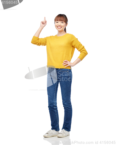 Image of happy asian woman pointing finger up over white