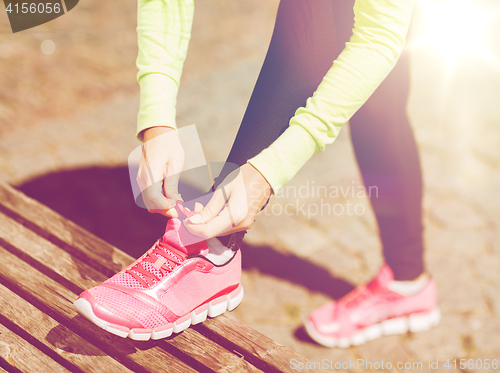 Image of runner woman lacing trainers shoes