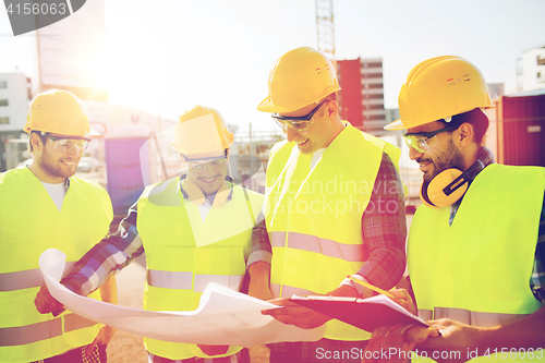 Image of group of builders with tablet pc and blueprint