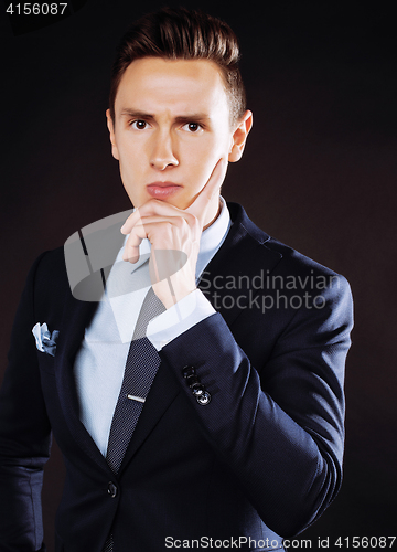 Image of young pretty business man standing on black background, modern h