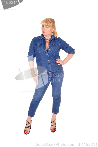 Image of Woman in jeans clothing standing.