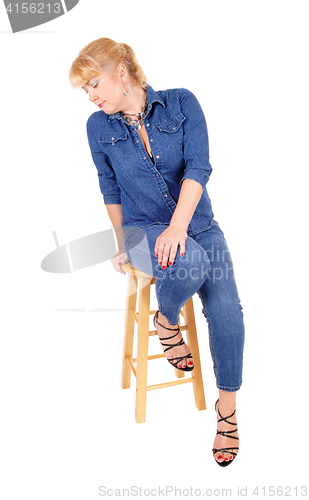 Image of Blond woman sitting on chair.