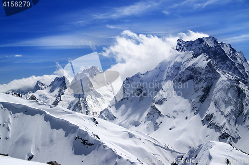 Image of Winter mountains with snow cornice and blue sky with clouds in n