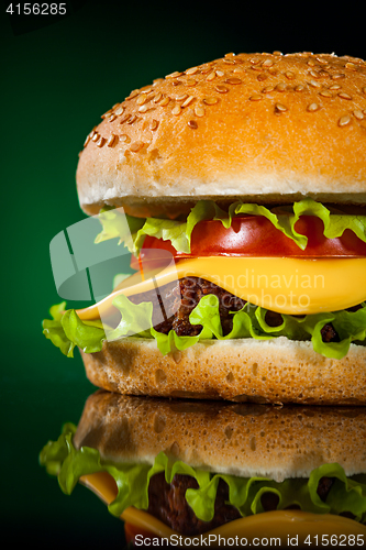 Image of Tasty and appetizing hamburger on a darkly green