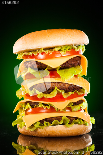 Image of Tasty and appetizing hamburger on a darkly green