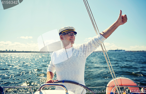 Image of senior man at helm on boat or yacht sailing in sea