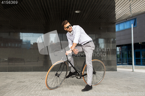 Image of man with bicycle and headphones on city street