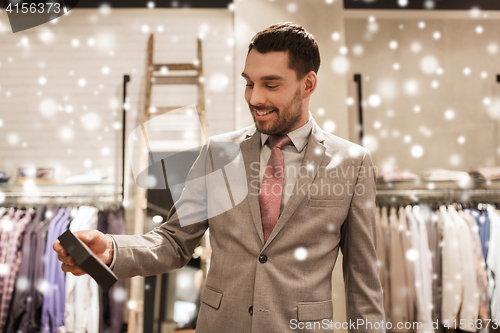 Image of happy man holding little box in clothing store