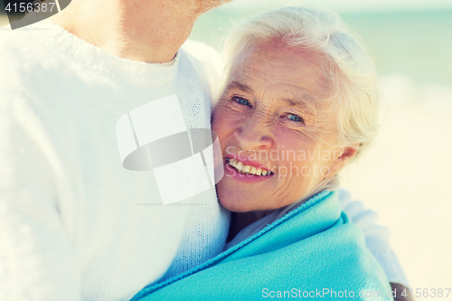 Image of happy senior couple hugging on summer beach