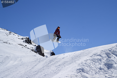 Image of Snowboarder jumping in terrain park at ski resort on sun winter 