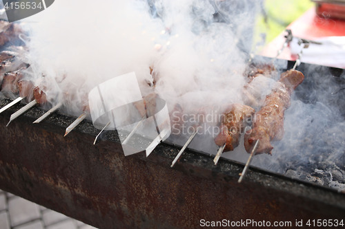 Image of Grilling marinated shashlik on a grill. Shish kebab popular in Eastern, Central Europe and other places. 