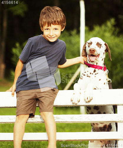 Image of little cute boy with dalmatian dog