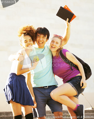 Image of cute group of teenages at the building of university with books huggings