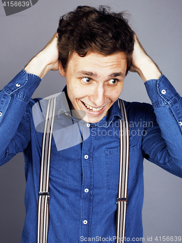 Image of young goofy man with pimples pointing in studio