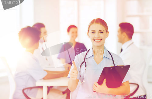 Image of happy doctor over group of medics at hospital