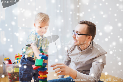 Image of father and son playing with toy blocks at home