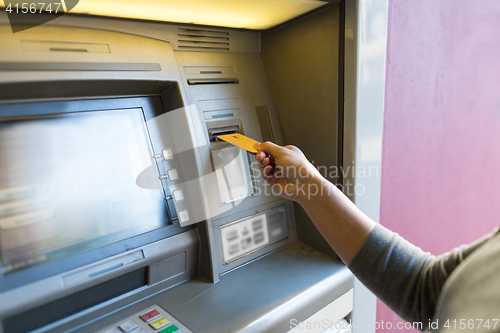 Image of close up of woman inserting card to atm machine