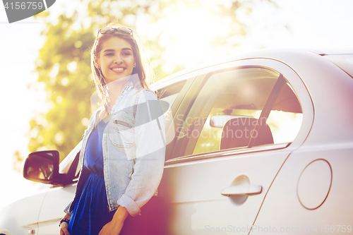 Image of happy teenage girl or young woman in car