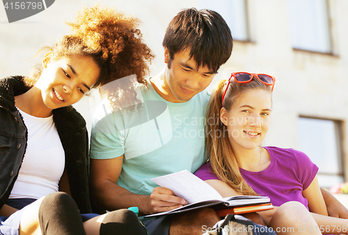 Image of cute group of teenages at the building of university with books huggings