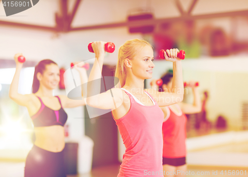 Image of group of smiling women working out with dumbbells