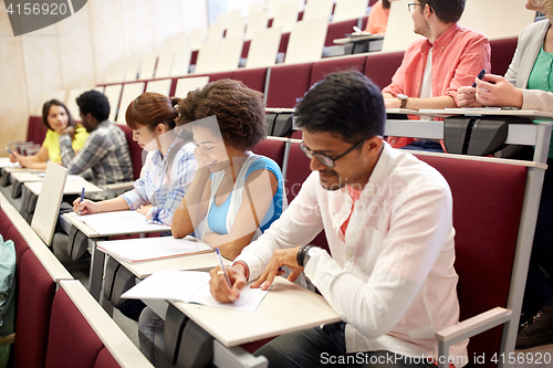 Image of group of students with notebooks in lecture hall