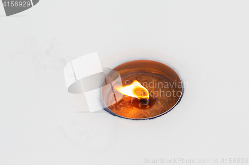 Image of christmas outdoor candle burning on snow in winter