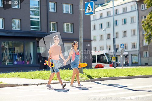 Image of teenage couple with skateboards on city street