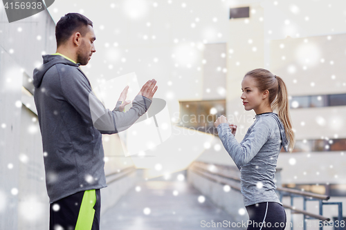 Image of woman with coach working out strike outdoors