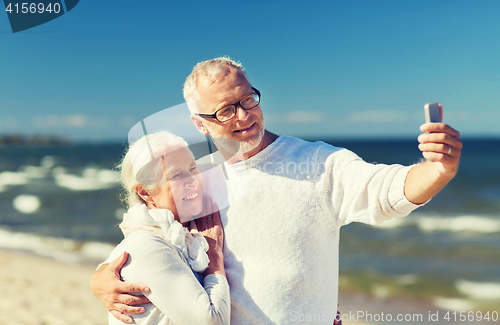 Image of happy senior couple hugging on summer beach