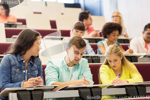 Image of group of students with notebooks in lecture hall