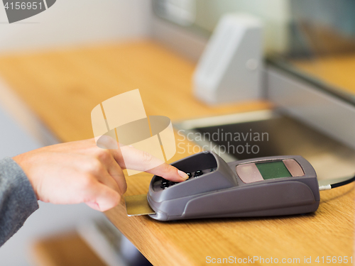 Image of hand entering pin code to card reader terminal