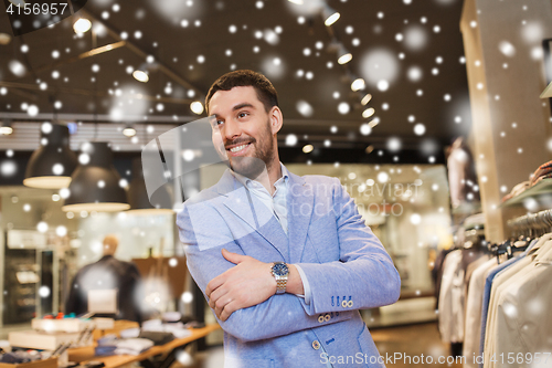 Image of happy young man in jacket at clothing store