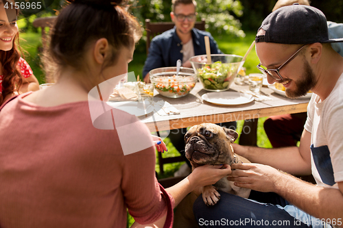 Image of happy friends having dinner at summer garden party