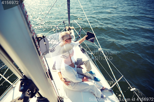 Image of senior couple with tablet pc on sail boat or yacht