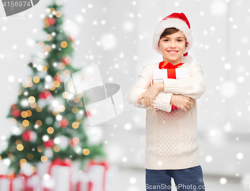 Image of smiling happy boy in santa hat with gift box