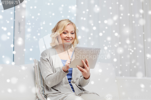 Image of happy middle aged woman with tablet pc at home