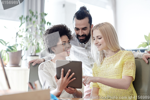 Image of happy creative team with tablet pc in office