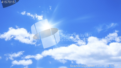 Image of blue sky with some clouds and the sun