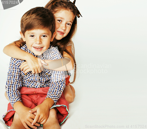 Image of little cute boy and girl hugging playing on white background, ha