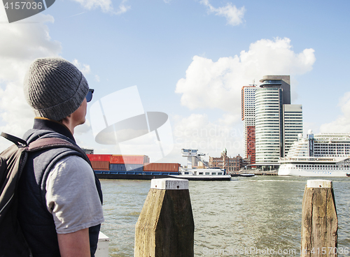 Image of Young modern guy in hat and sunglasses, tourist with backpack lo