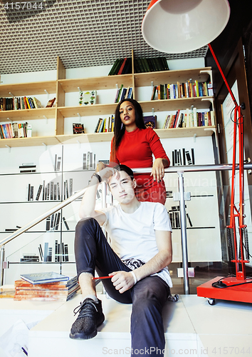 Image of couple students in univercity library, looking book, preparing t