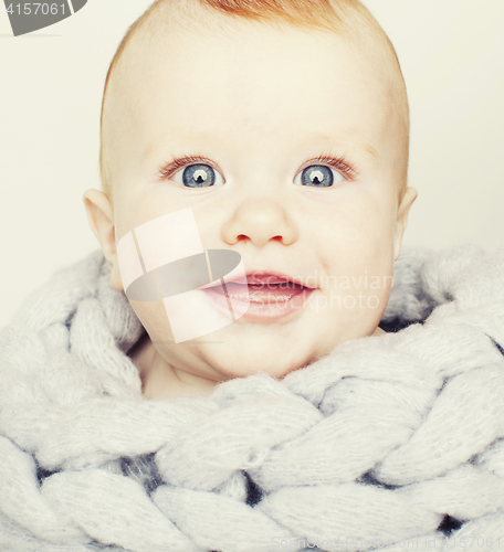 Image of little cute red head baby in scarf all over him close up isolate