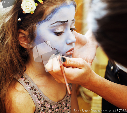 Image of little cute child making facepaint on birthday party, zombie Apo