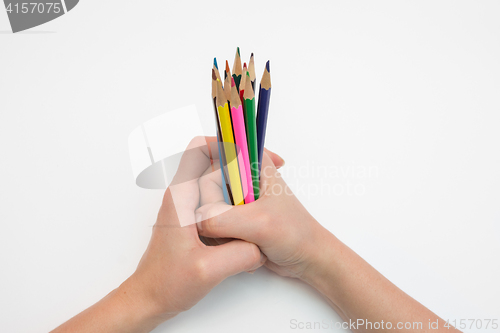 Image of Female hand clenched in a fist dozen pencils