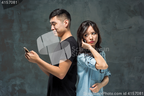 Image of Asian young couple using cellphone, closeup portrait.