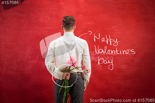 Image of Man holding bouquet of carnations behind back